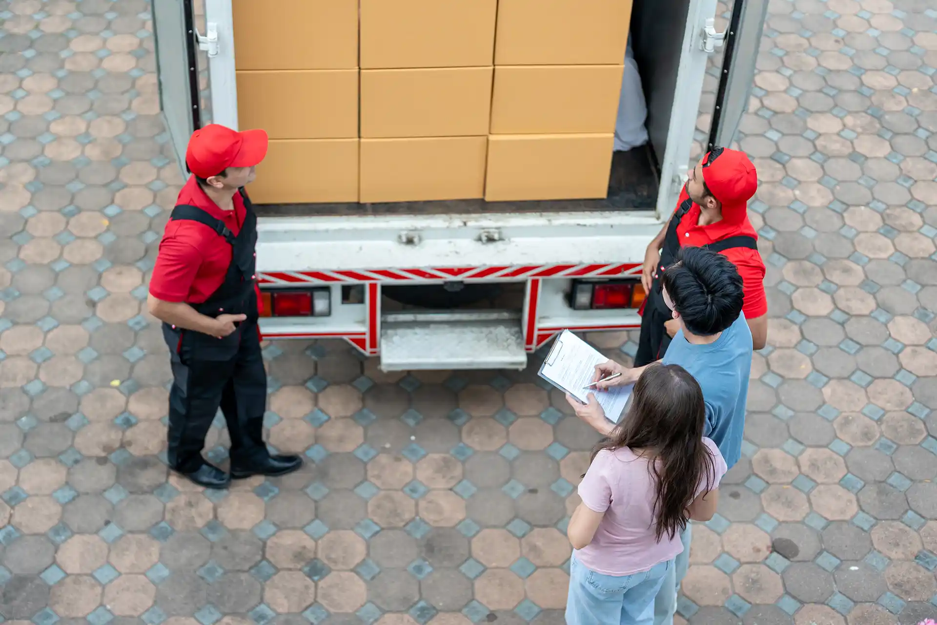 Zusteller liefert Paket an junges Paar im Haus aus.